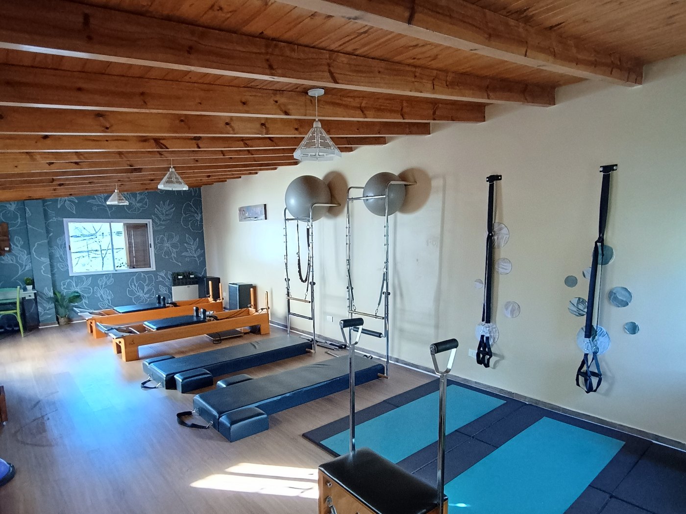 Sala de Toulouse Pilates Parque Chacabuco con techo de vigas de madera