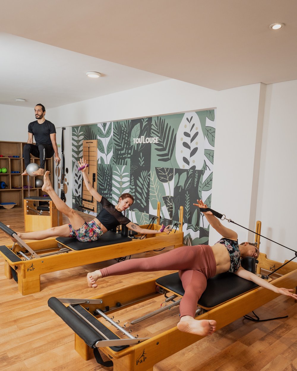 Clase de Pilates en Reformers frente al mural de Toulouse Colegiales